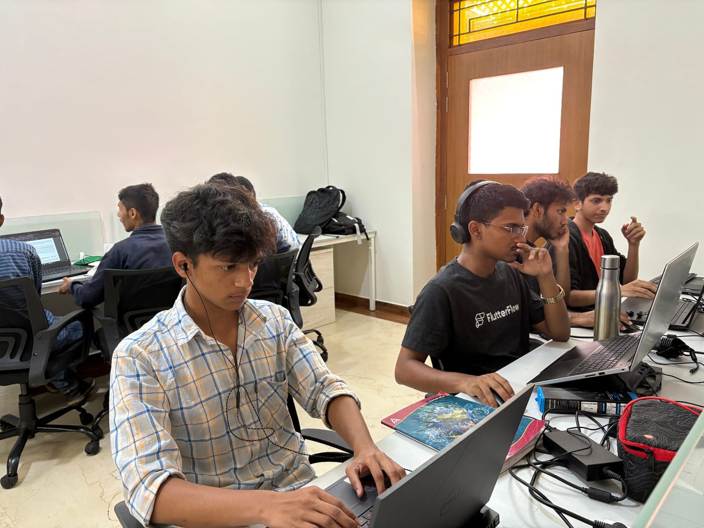 Jared Furtado and teammates coding on laptops during a hackathon